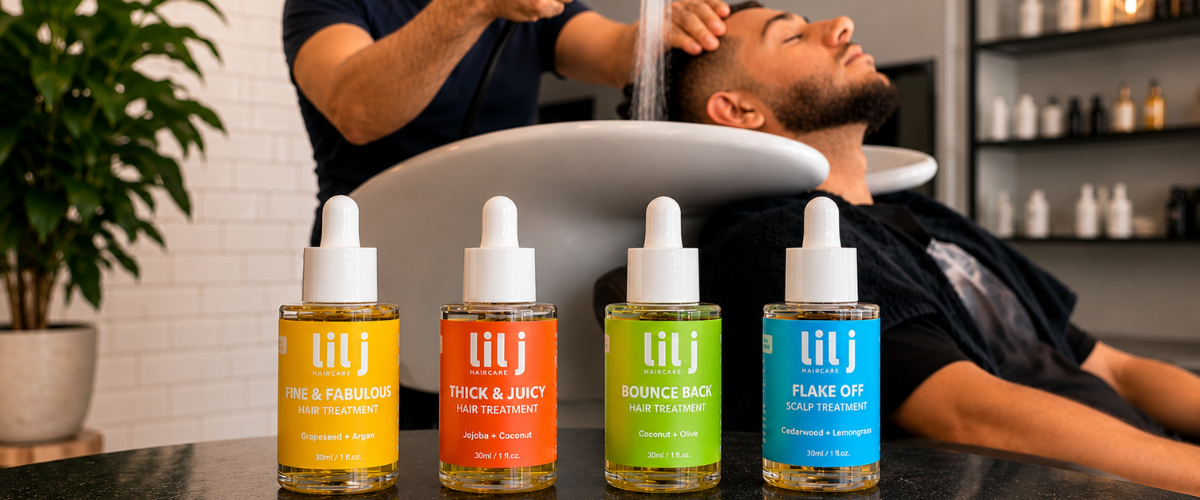 Lil J Haircare Pre-Wash treatments on a counter with a person getting a haircut in the background.